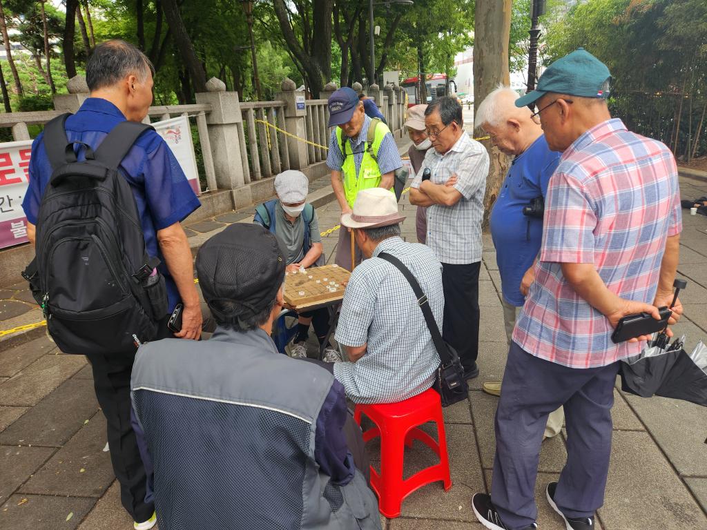 　　8月27日，首尔市钟路区塔谷公园旁的街边，老人们在下象棋。新华社记者陆爱华摄